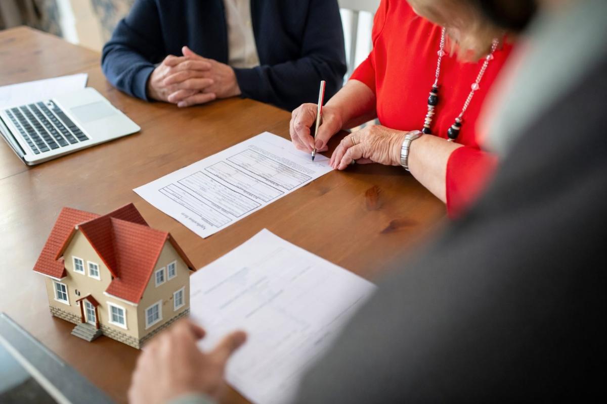 Personas revisan y firman documentación vinculada a una operación inmobiliaria, en un contexto marcado por los cambios de Inocencia Fiscal II y las obligaciones tributarias
